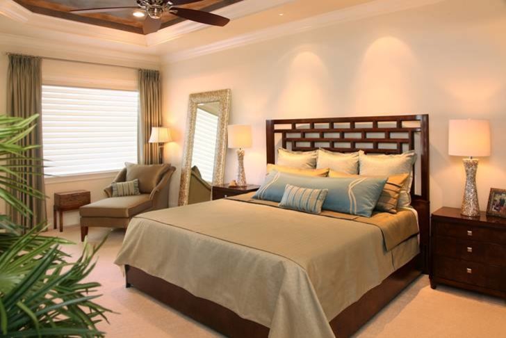 Modelo de dormitorio principal tropical grande sin chimenea con paredes grises, moqueta y suelo beige