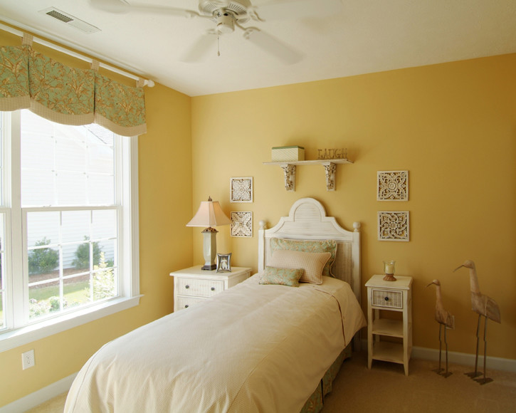На фото: гостевая спальня среднего размера, (комната для гостей) в классическом стиле с желтыми стенами, ковровым покрытием и стандартным камином с