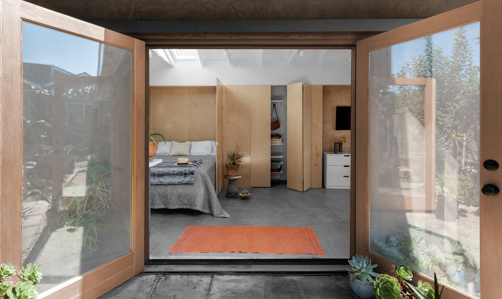 ロサンゼルスにある小さなビーチスタイルのおしゃれな主寝室 (白い壁、コンクリートの床、グレーの床) のレイアウト