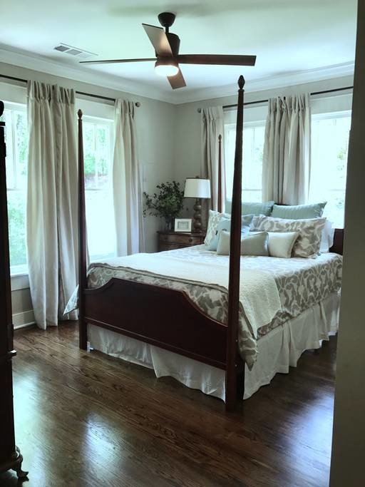 This is an example of a medium sized country master bedroom in Atlanta with beige walls, dark hardwood flooring and brown floors.