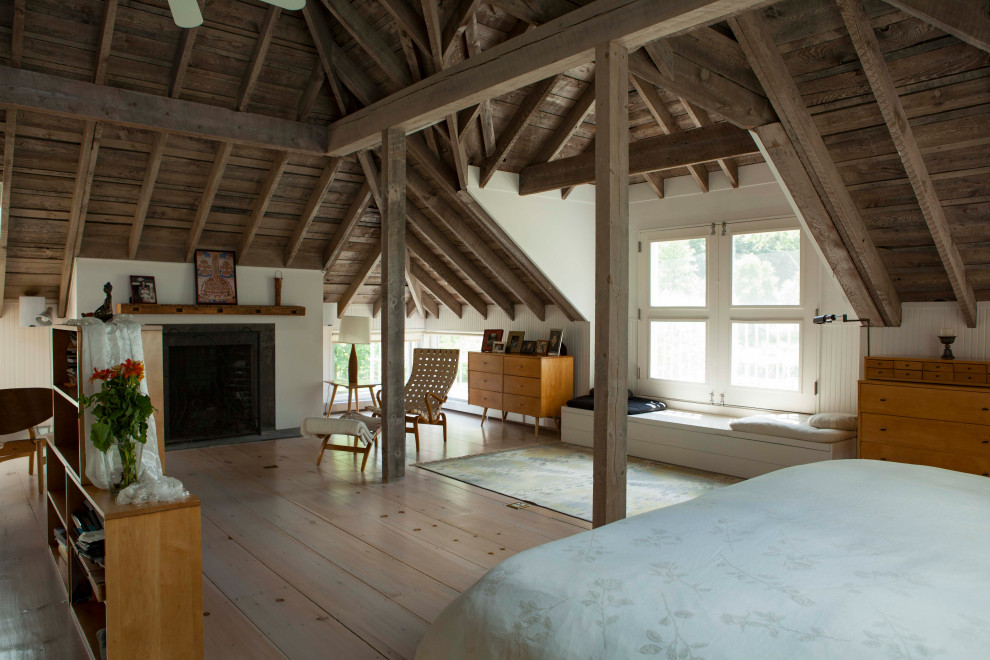 Foto di una camera da letto country con pareti bianche, parquet chiaro, camino classico e pavimento beige