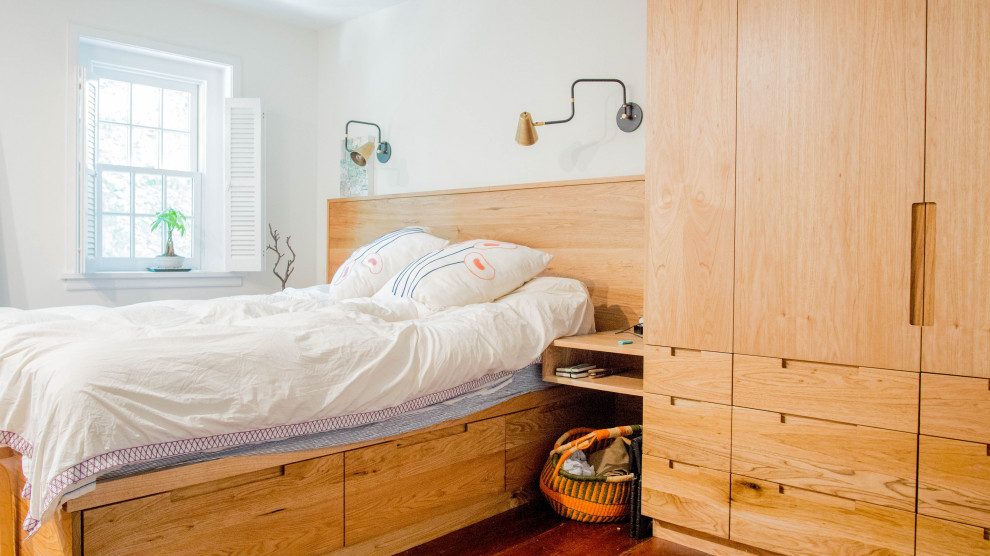This is an example of an eclectic bedroom in Philadelphia with white walls, dark hardwood flooring and brown floors.