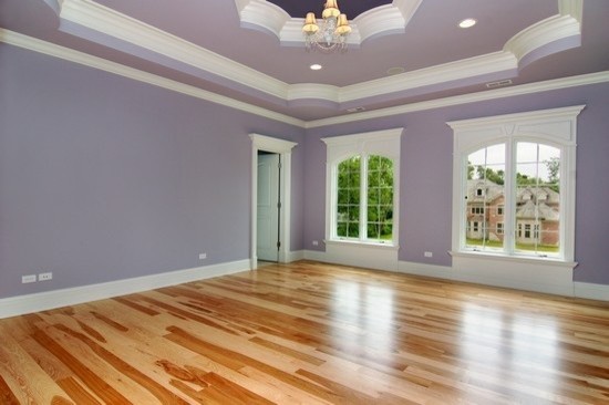 Cette image montre une grande chambre d'amis victorienne avec un mur violet, parquet clair et aucune cheminée.