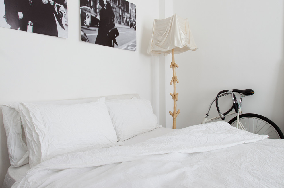 На фото: гостевая спальня среднего размера, (комната для гостей) в стиле модернизм с белыми стенами и бетонным полом без камина с