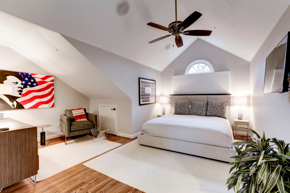 Modelo de habitación de invitados abovedada clásica renovada de tamaño medio con paredes grises, suelo de madera en tonos medios y suelo marrón