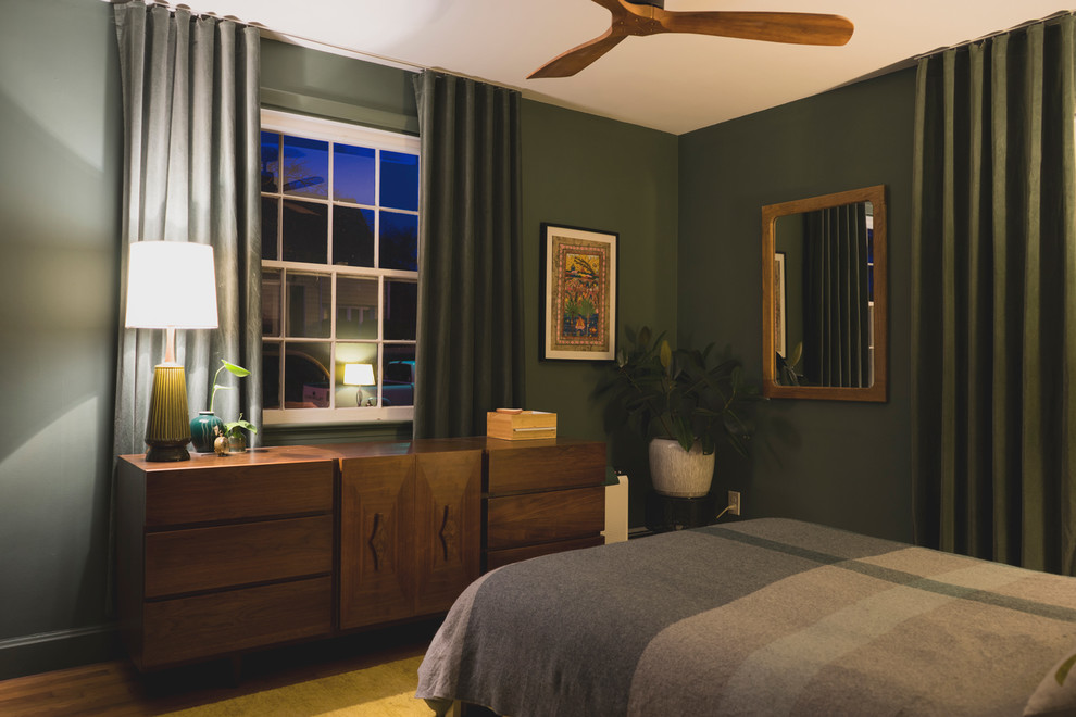 Ejemplo de dormitorio principal clásico renovado de tamaño medio sin chimenea con paredes verdes, suelo de madera en tonos medios y suelo marrón