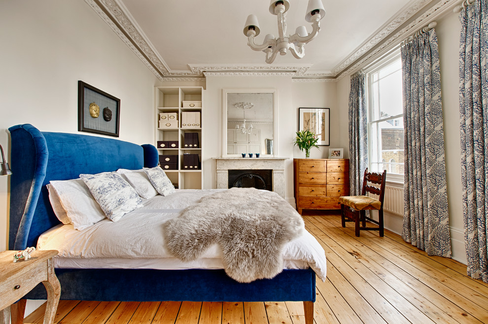 На фото: хозяйская спальня среднего размера в классическом стиле с белыми стенами, стандартным камином, фасадом камина из камня и паркетным полом среднего тона с