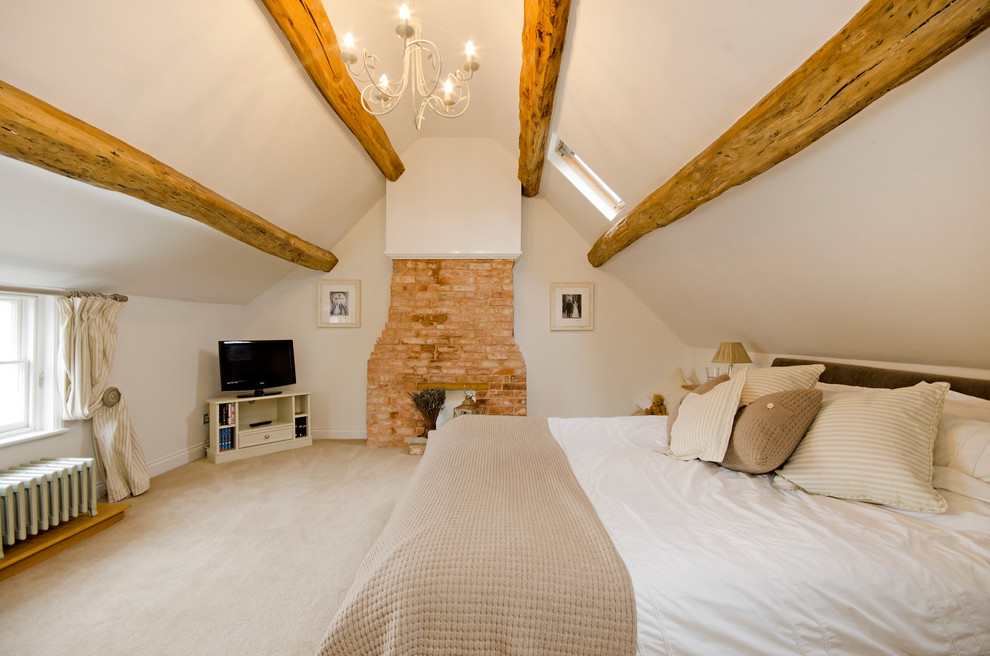 Farmhouse carpeted bedroom photo in London with white walls, a standard fireplace and a brick fireplace