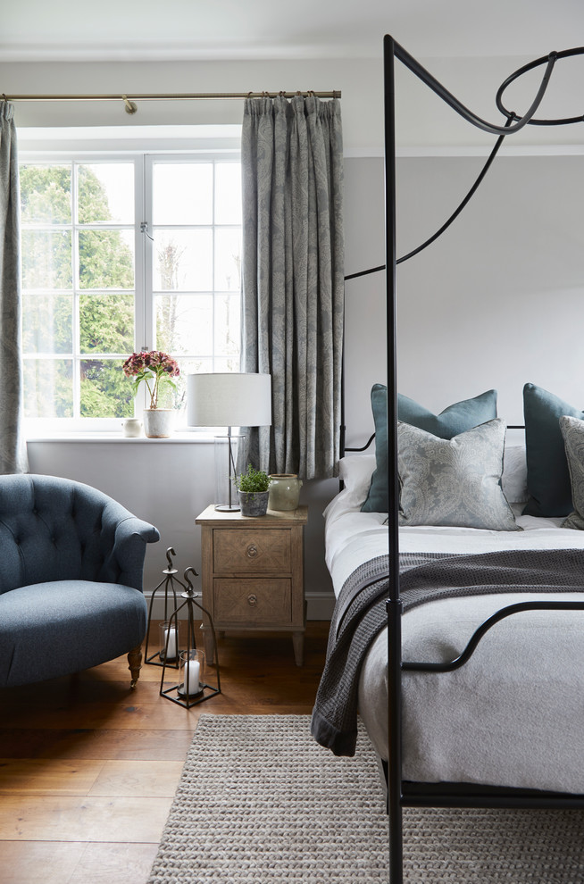 ハートフォードシャーにあるトランジショナルスタイルのおしゃれな客用寝室 (グレーの壁、無垢フローリング、茶色い床、グレーとブラウン) のレイアウト