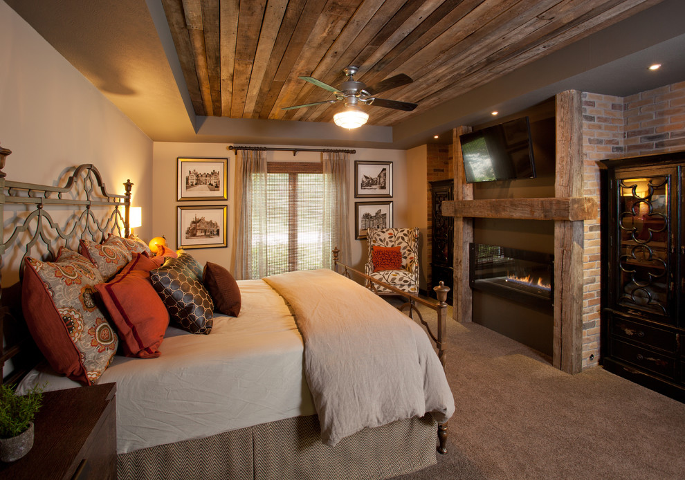 Пример оригинального дизайна: хозяйская спальня среднего размера в стиле рустика с бежевыми стенами, ковровым покрытием, горизонтальным камином, фасадом камина из дерева, бежевым полом и тюлем