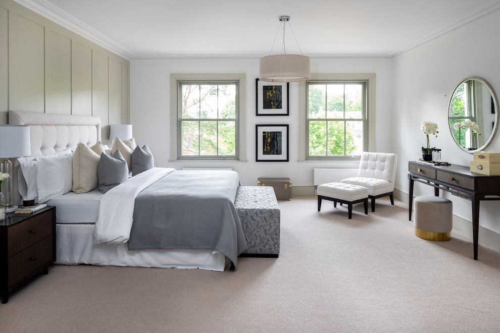 This is an example of a large traditional master bedroom in London with white walls, carpet, beige floors and a feature wall.