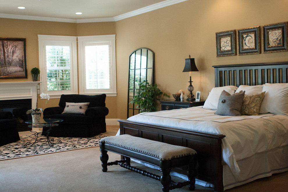 На фото: хозяйская спальня среднего размера в классическом стиле с коричневыми стенами, ковровым покрытием, стандартным камином, фасадом камина из штукатурки и бежевым полом