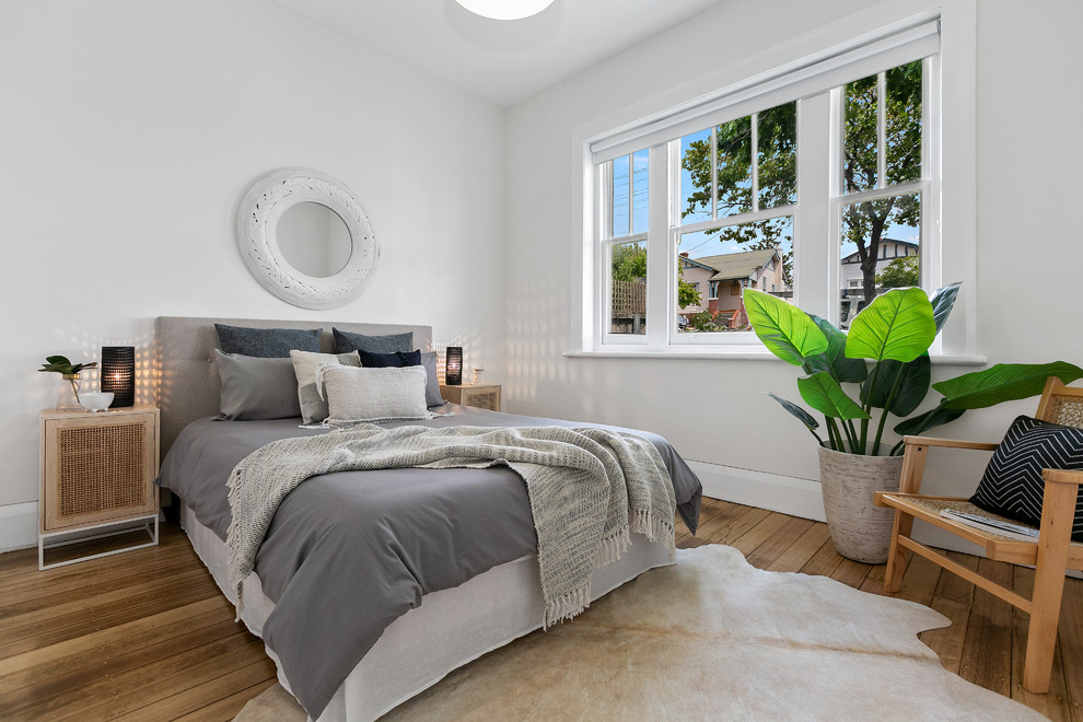 Photo of a contemporary master and grey and brown bedroom in Hobart with white walls, medium hardwood flooring and brown floors.