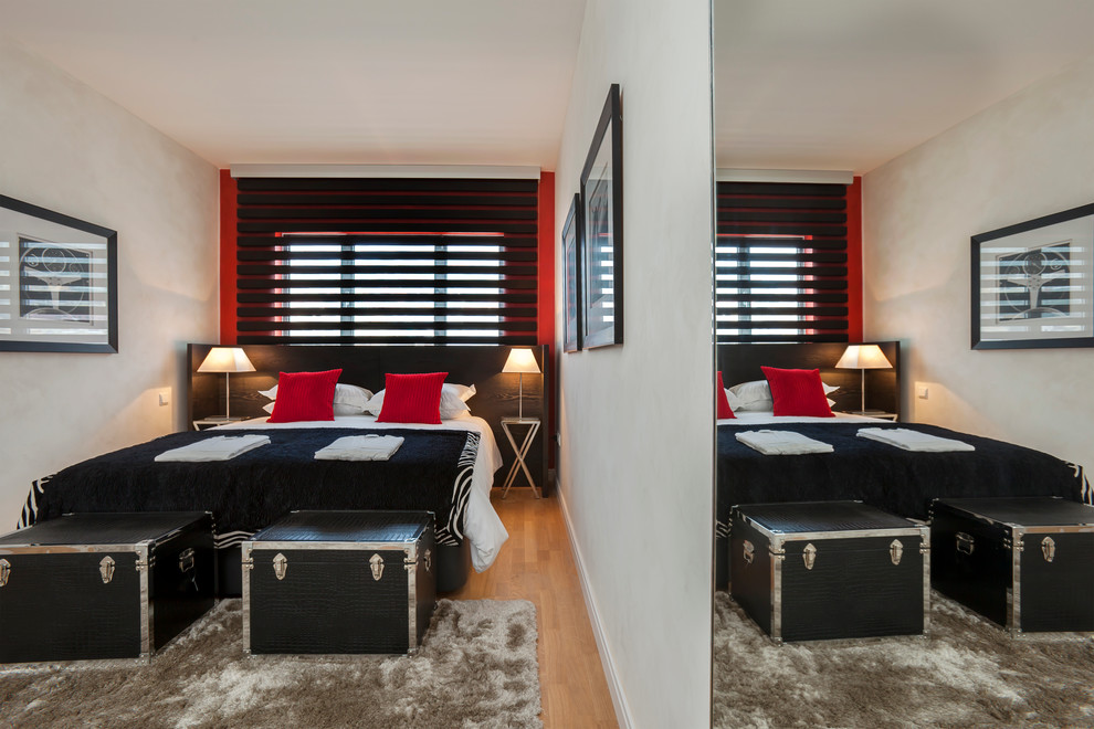 Diseño de dormitorio principal retro de tamaño medio sin chimenea con paredes blancas y suelo de madera en tonos medios