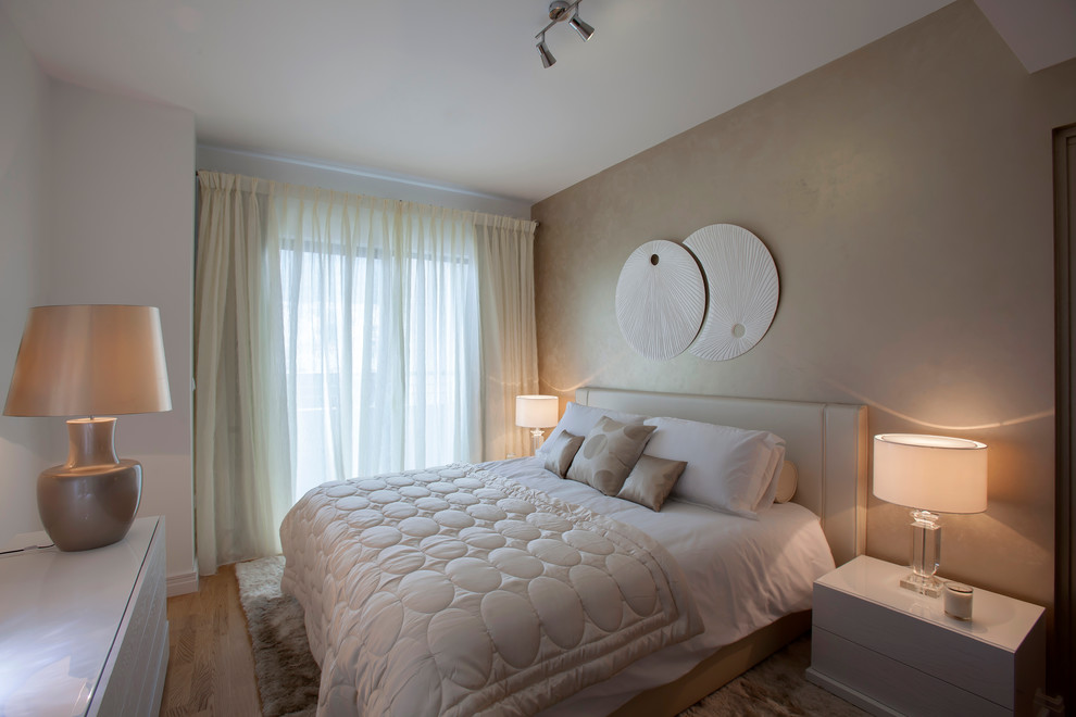 Foto de dormitorio principal actual de tamaño medio sin chimenea con paredes multicolor y suelo de madera en tonos medios
