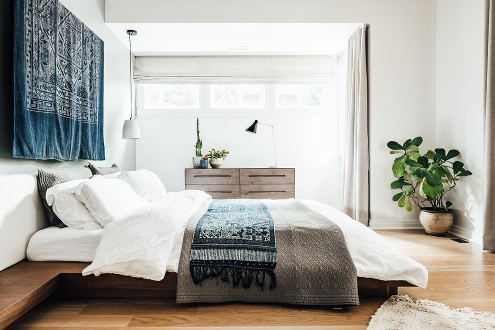 Ejemplo de dormitorio principal mediterráneo de tamaño medio sin chimenea con paredes blancas, suelo de madera clara y suelo beige