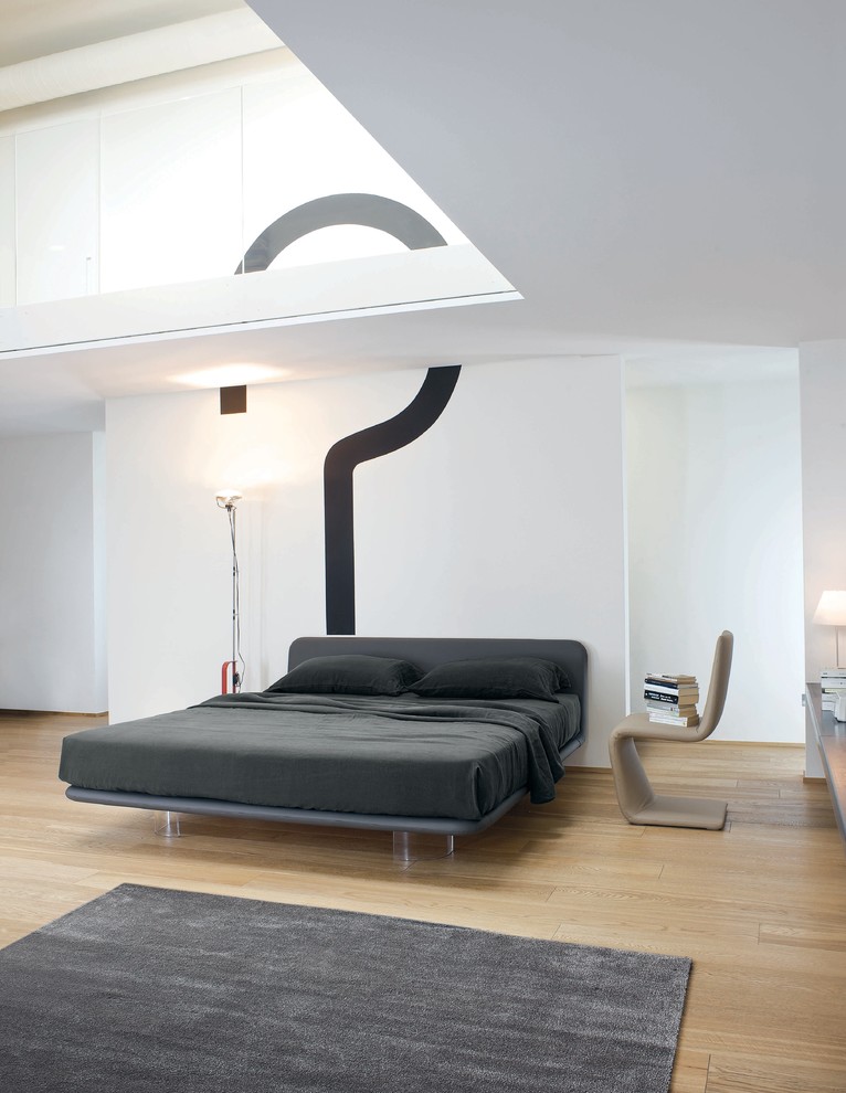 Modelo de dormitorio principal minimalista grande con paredes blancas, suelo de madera en tonos medios y suelo amarillo