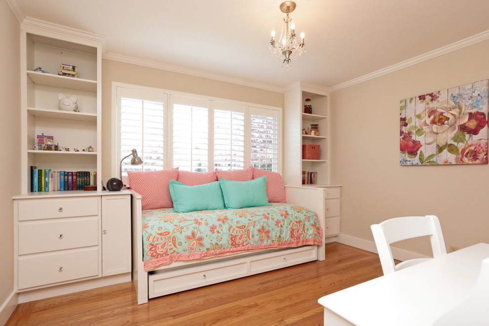 Foto di una camera da letto tradizionale con pareti beige e parquet chiaro