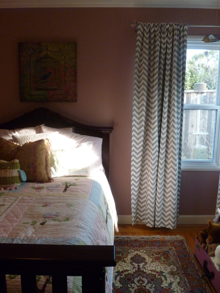 Réalisation d'une chambre bohème de taille moyenne avec un mur rose et parquet clair.