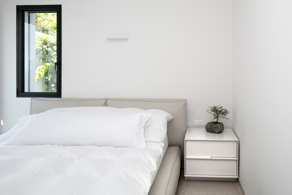 Diseño de dormitorio principal moderno de tamaño medio sin chimenea con paredes grises y suelo de piedra caliza