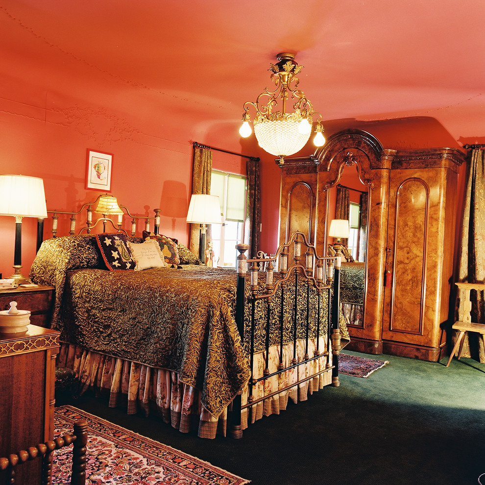 Пример оригинального дизайна: большая хозяйская спальня в викторианском стиле с оранжевыми стенами, ковровым покрытием и зеленым полом