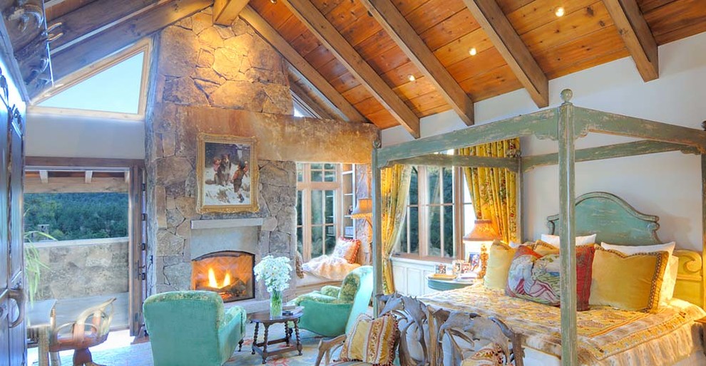 Cette image montre une chambre parentale minimaliste avec un mur blanc, un sol en bois brun, une cheminée standard et un manteau de cheminée en pierre.