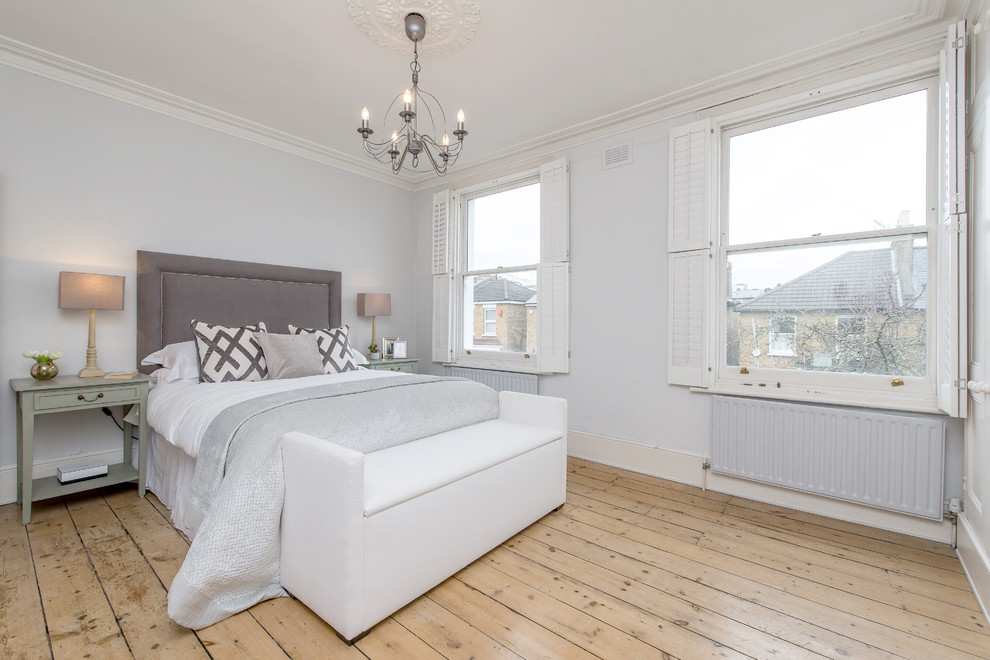 Ejemplo de dormitorio tradicional renovado con paredes grises, suelo de madera clara y suelo beige