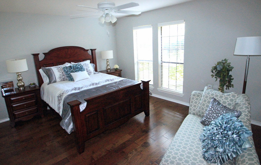 Ejemplo de dormitorio tradicional de tamaño medio con paredes grises y suelo de madera oscura