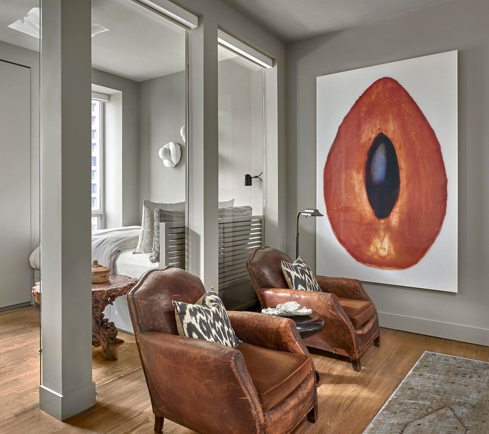 Mittelgroßes Gästezimmer ohne Kamin mit grauer Wandfarbe und hellem Holzboden in Chicago