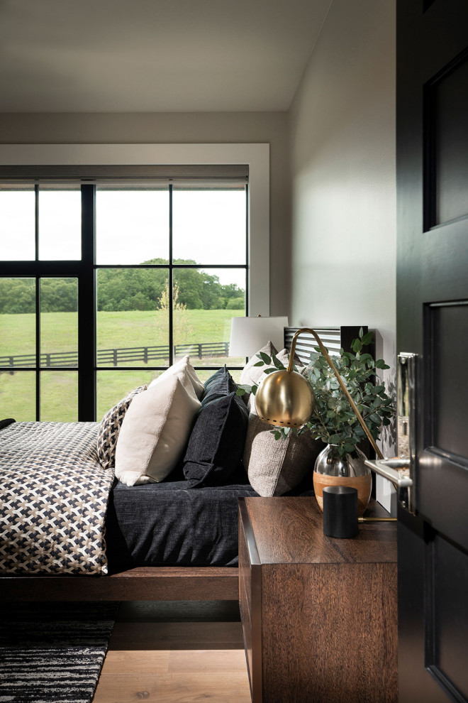 Diseño de habitación de invitados moderna de tamaño medio con paredes grises, suelo de madera clara y suelo marrón