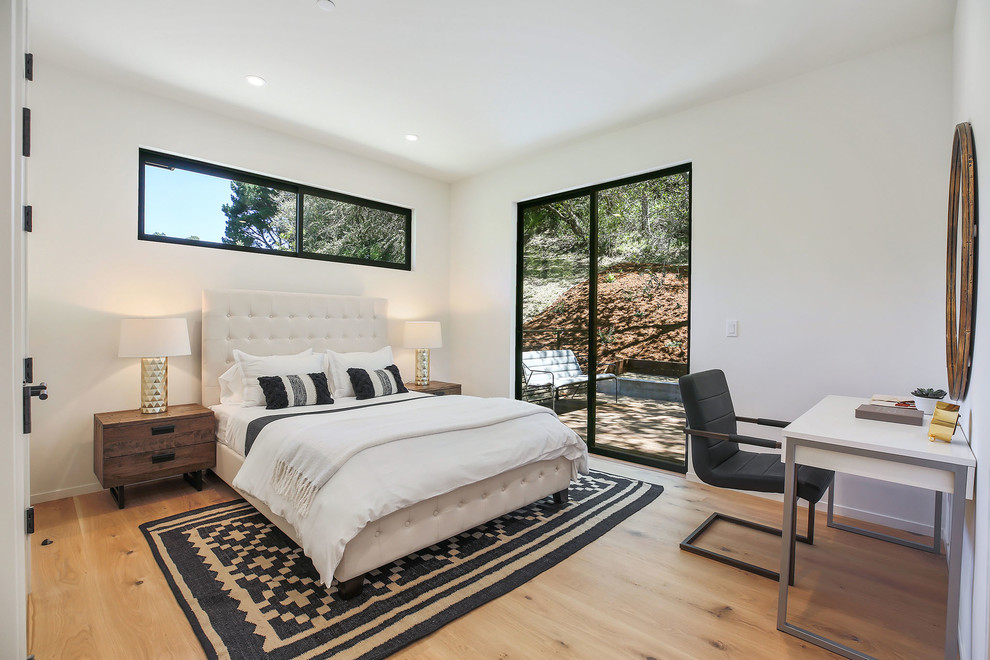 This is an example of a contemporary cream and black bedroom in Sacramento with white walls, medium hardwood flooring and brown floors.