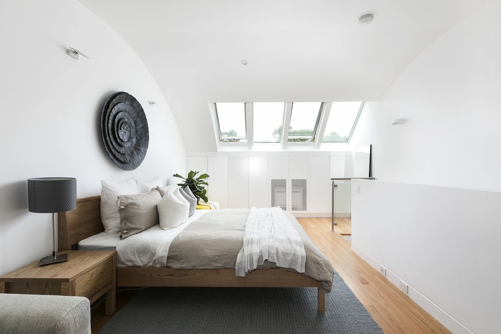 他の地域にある中くらいなコンテンポラリースタイルのおしゃれなロフト寝室 (白い壁、無垢フローリング、茶色い床、グレーとブラウン) のインテリア