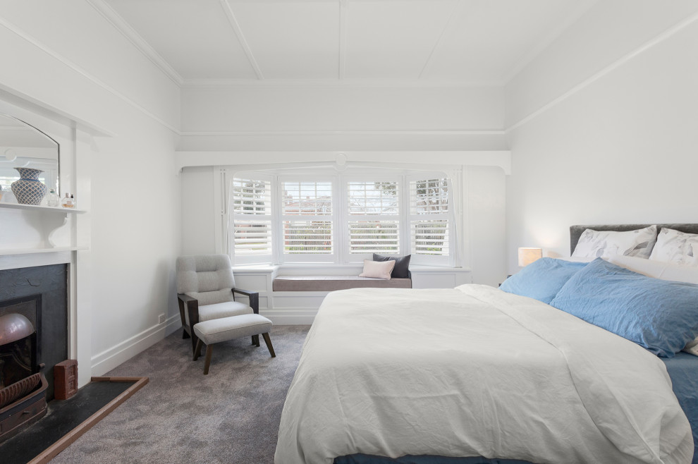 Imagen de dormitorio principal actual de tamaño medio con paredes blancas, moqueta, todas las chimeneas, marco de chimenea de metal, suelo gris y casetón
