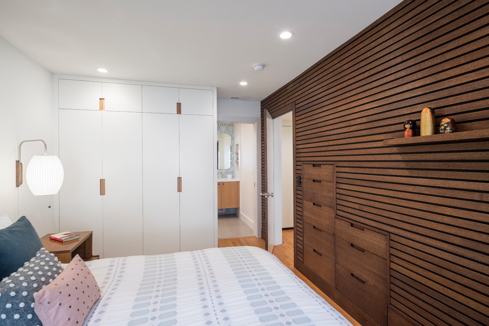 Esempio di una camera matrimoniale contemporanea con pareti bianche, pavimento in legno massello medio e pavimento marrone