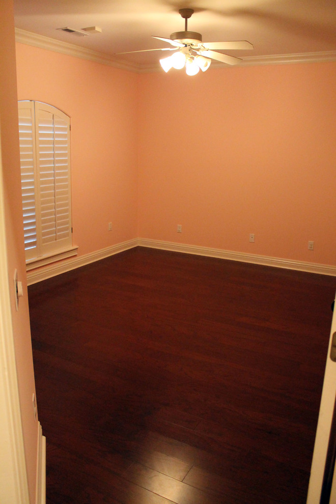Immagine di una grande camera da letto classica con pareti rosa e pavimento in legno massello medio