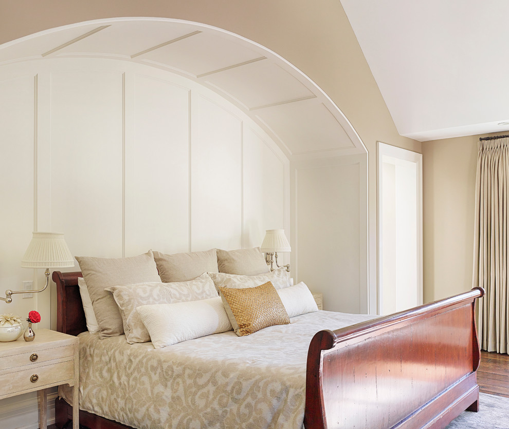 Inredning av ett klassiskt sovrum, med beige väggar och mellanmörkt trägolv