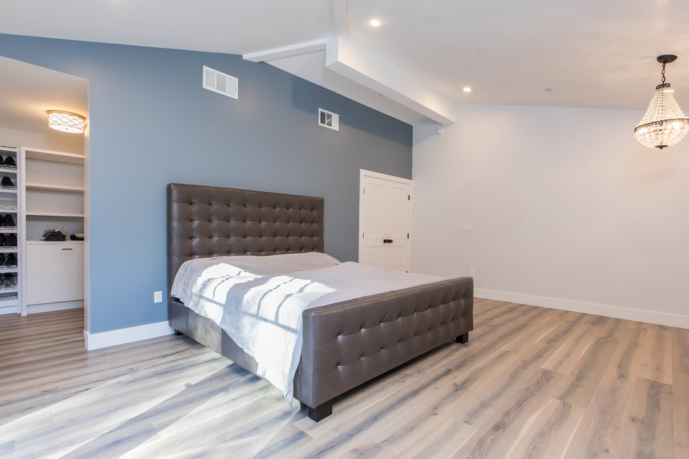 Imagen de dormitorio principal clásico renovado grande sin chimenea con paredes grises, suelo de madera clara y suelo beige