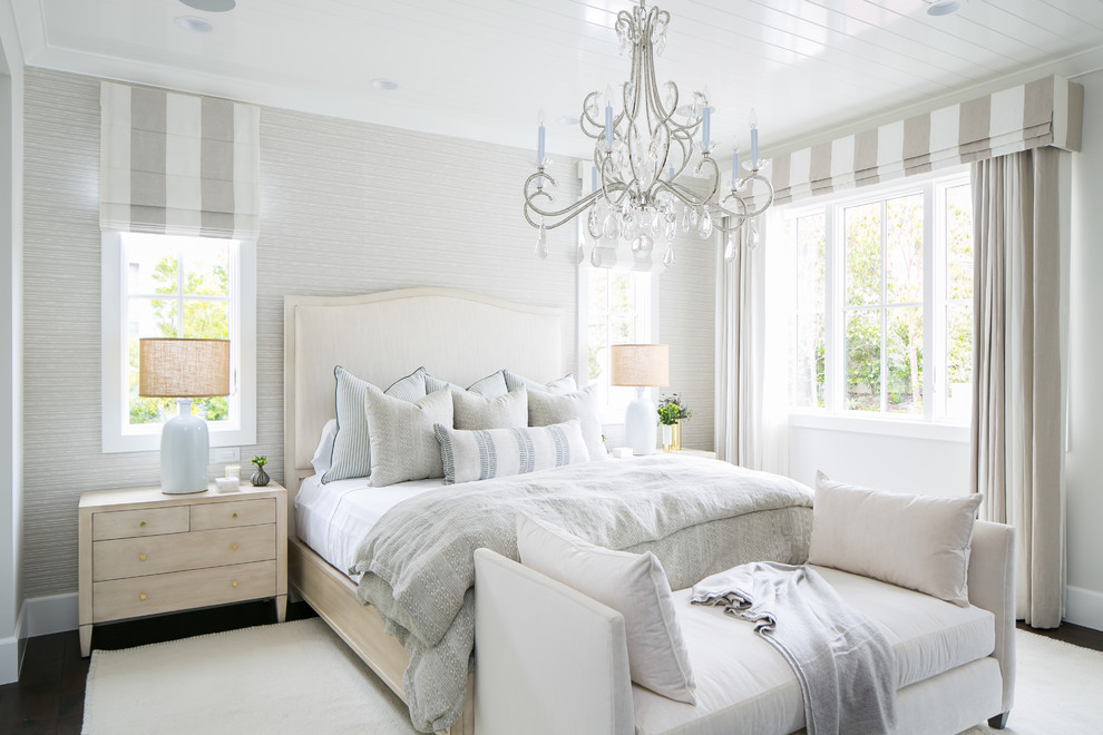 This is an example of a coastal bedroom in Orange County with white walls, dark hardwood flooring and brown floors.