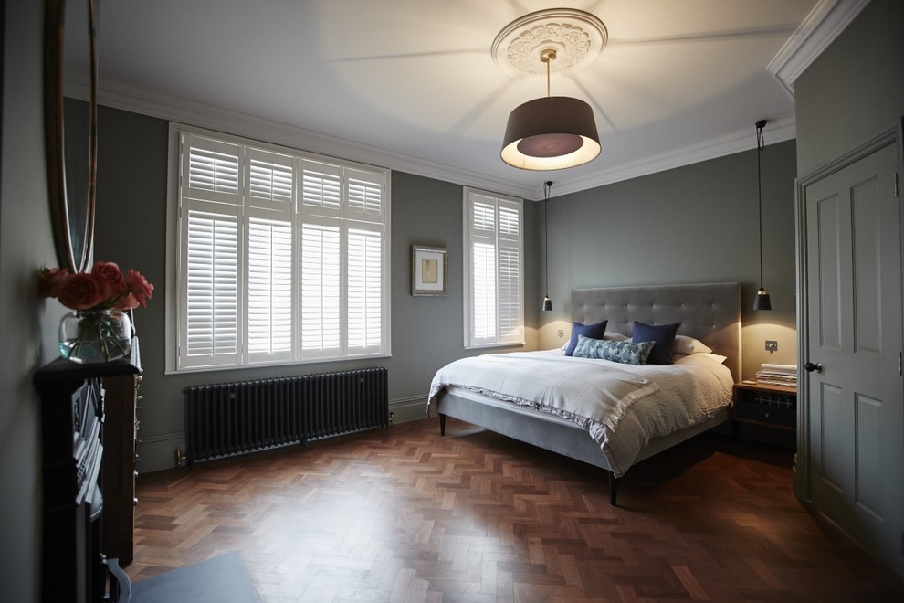 Ejemplo de dormitorio principal tradicional renovado de tamaño medio sin chimenea con paredes grises, suelo de madera oscura y suelo marrón