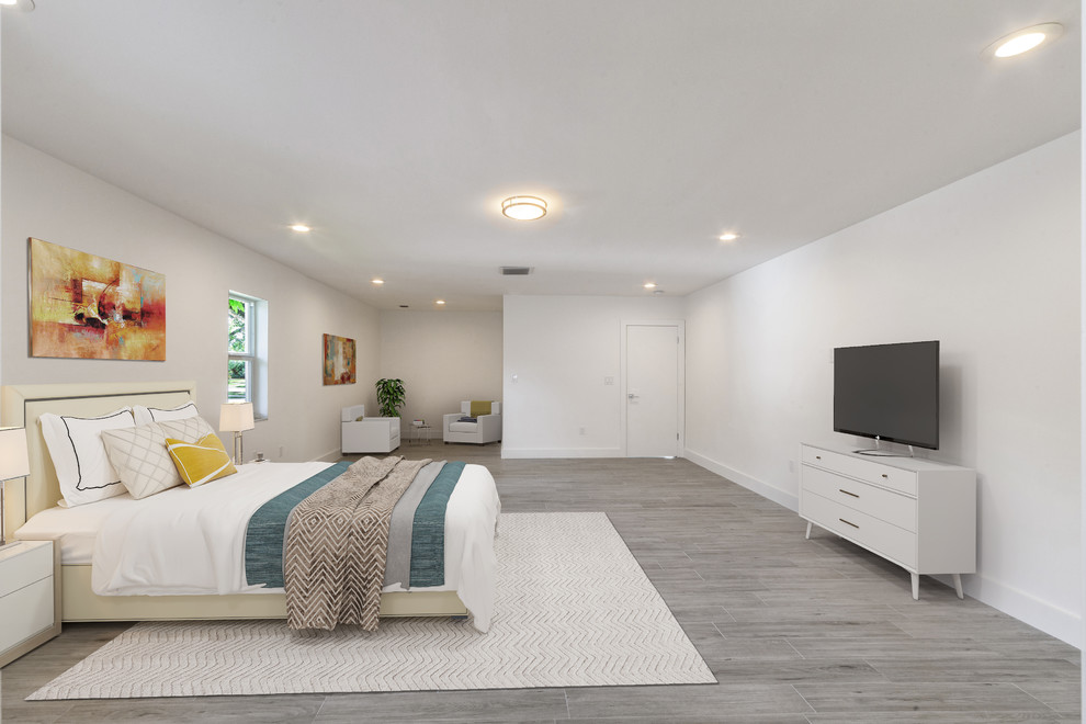 This is an example of an expansive contemporary master bedroom in Miami with white walls, medium hardwood flooring, no fireplace and grey floors.