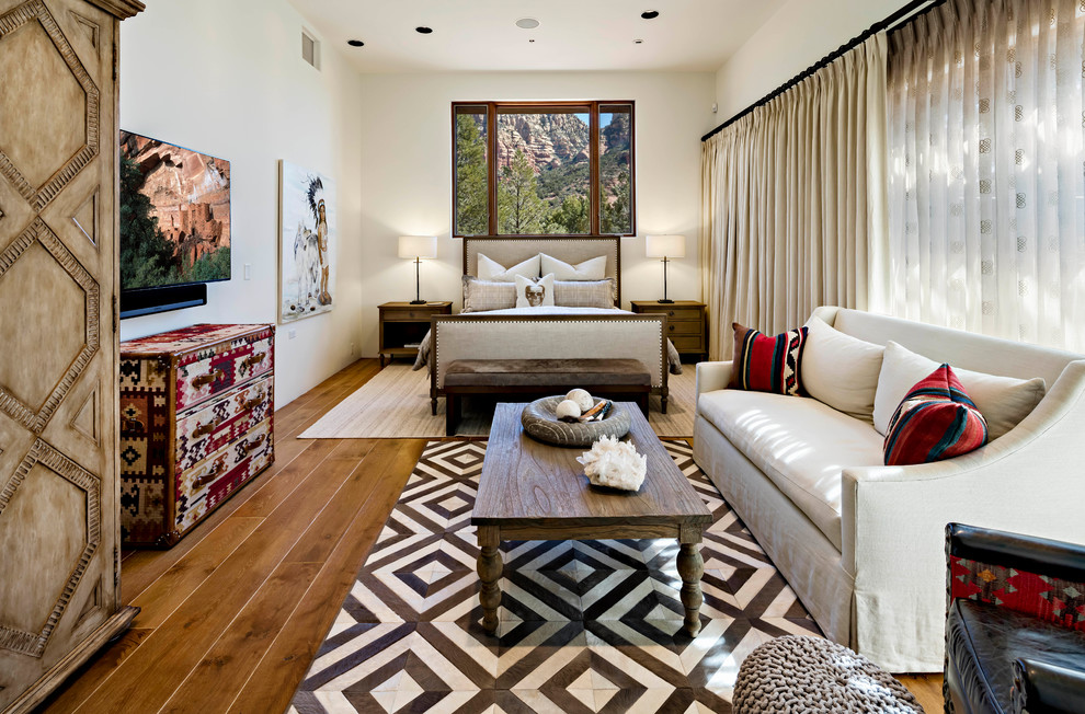 Foto di una camera da letto american style con pareti bianche, pavimento in legno massello medio e pavimento marrone