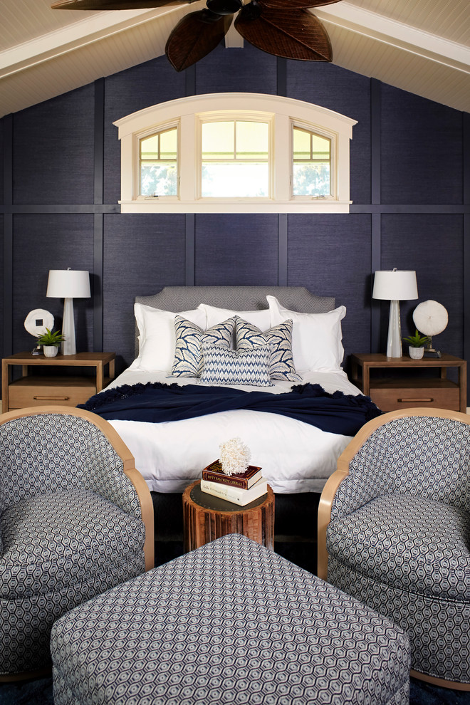 Imagen de dormitorio principal costero grande con paredes azules, moqueta, todas las chimeneas, marco de chimenea de madera y suelo beige