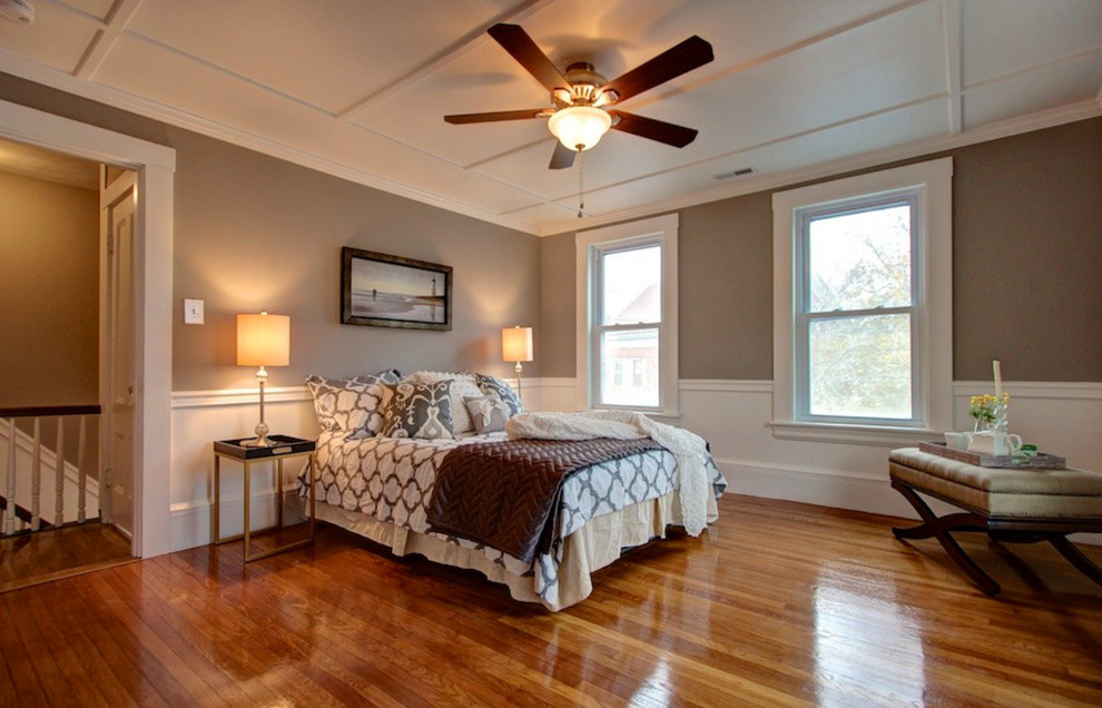 Example of a large classic master medium tone wood floor bedroom design in Boston with gray walls and no fireplace
