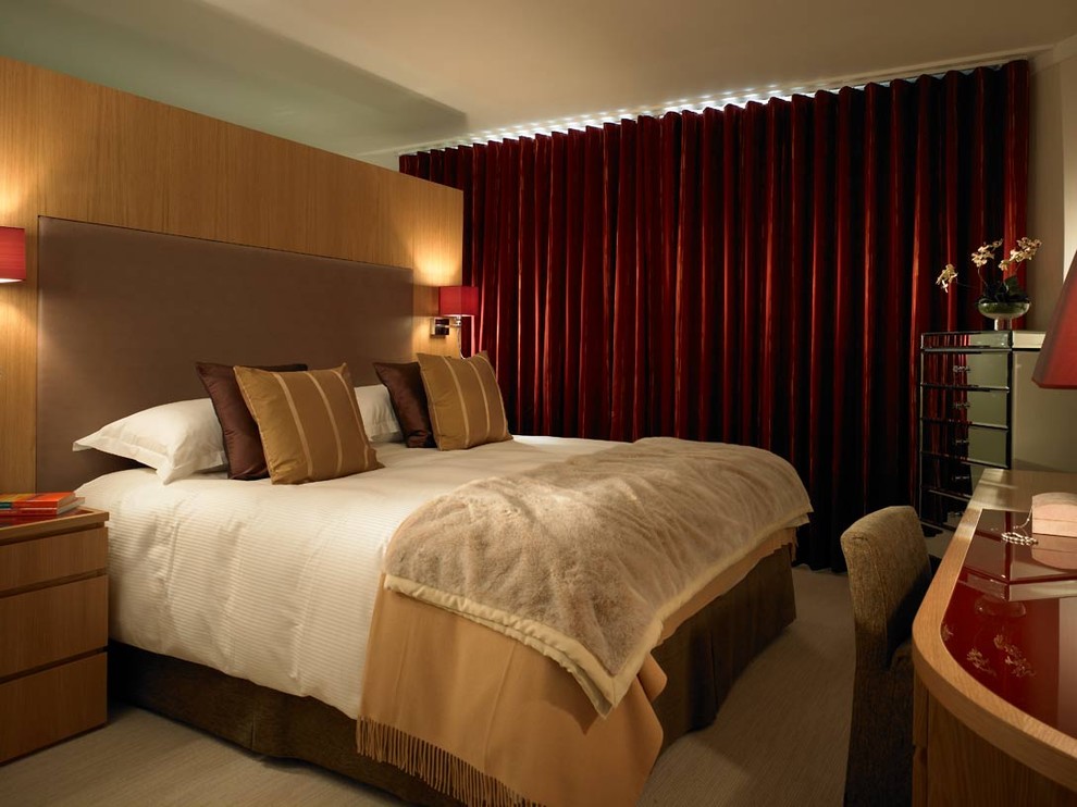 ロンドンにあるコンテンポラリースタイルのおしゃれな寝室 (ベージュの壁、カーペット敷き、赤いカーテン)