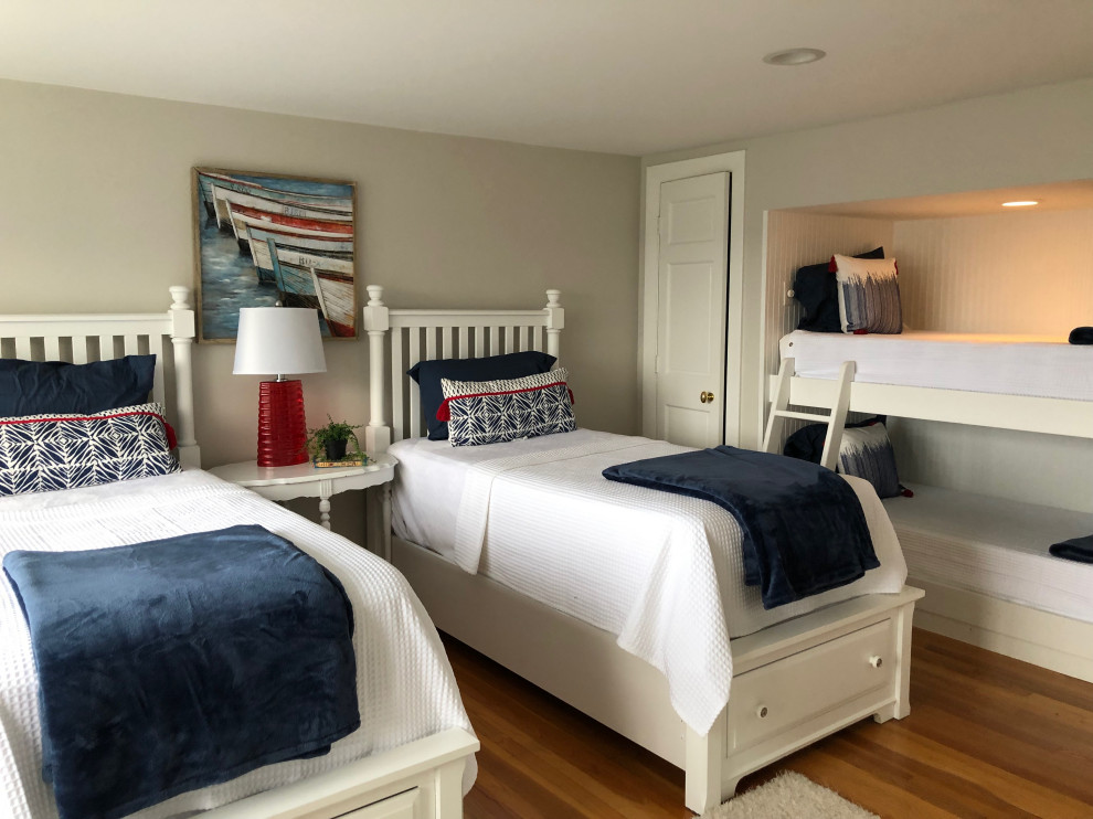 ボストンにある中くらいなビーチスタイルのおしゃれな客用寝室 (ベージュの壁、無垢フローリング、暖炉なし、茶色い床)