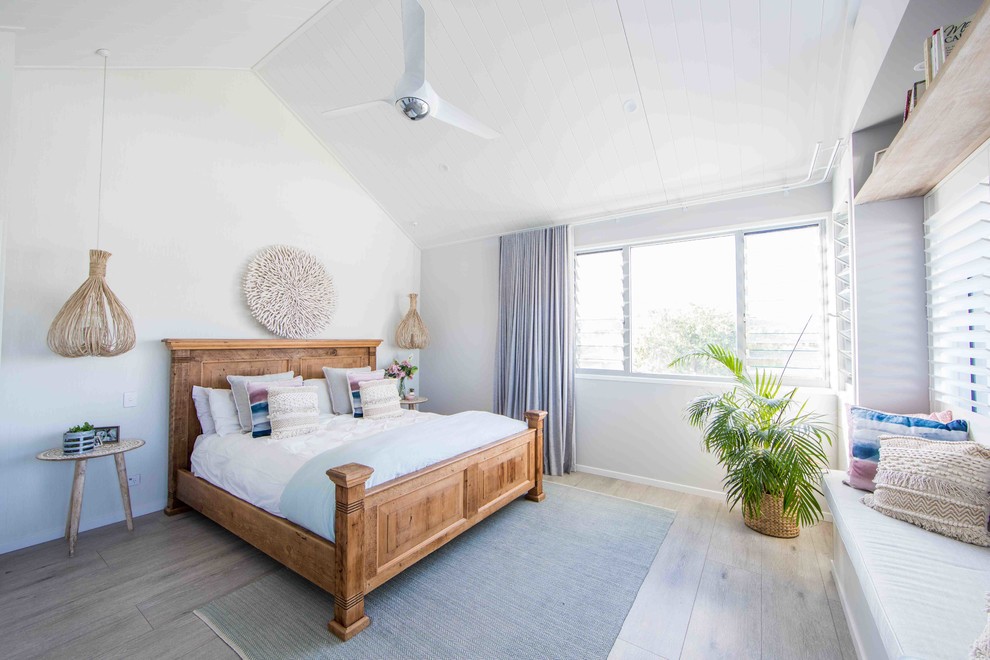 ゴールドコーストにある中くらいなビーチスタイルのおしゃれな主寝室 (白い壁、塗装フローリング、グレーの床)