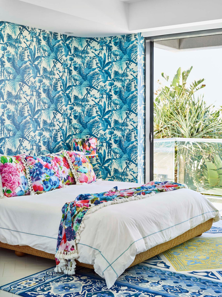 Immagine di una camera da letto design con pareti blu, pavimento beige e carta da parati