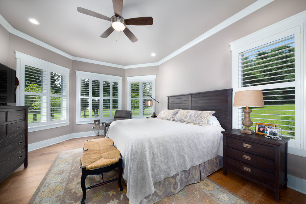 Photo of a large classic master bedroom in Other with grey walls, medium hardwood flooring and brown floors.