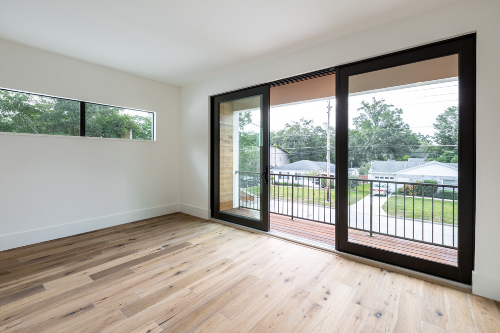 Photo of a medium sized modern guest bedroom in Austin with white walls and medium hardwood flooring.