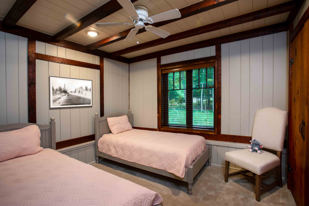 Ejemplo de habitación de invitados rural de tamaño medio con paredes beige, moqueta, suelo beige, vigas vistas y panelado